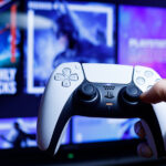 A PlayStation 5 DualShock remote is held up against a PlayStation Store backdrop.